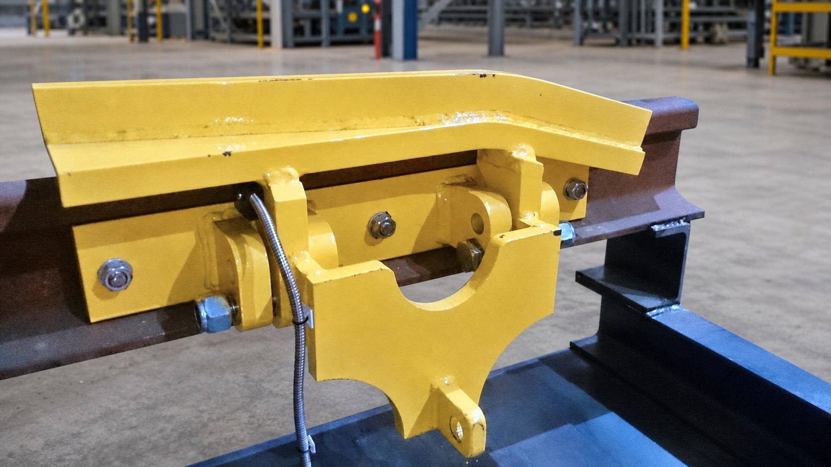 Close view of the yellow train derailer mechanism and protected position sensor