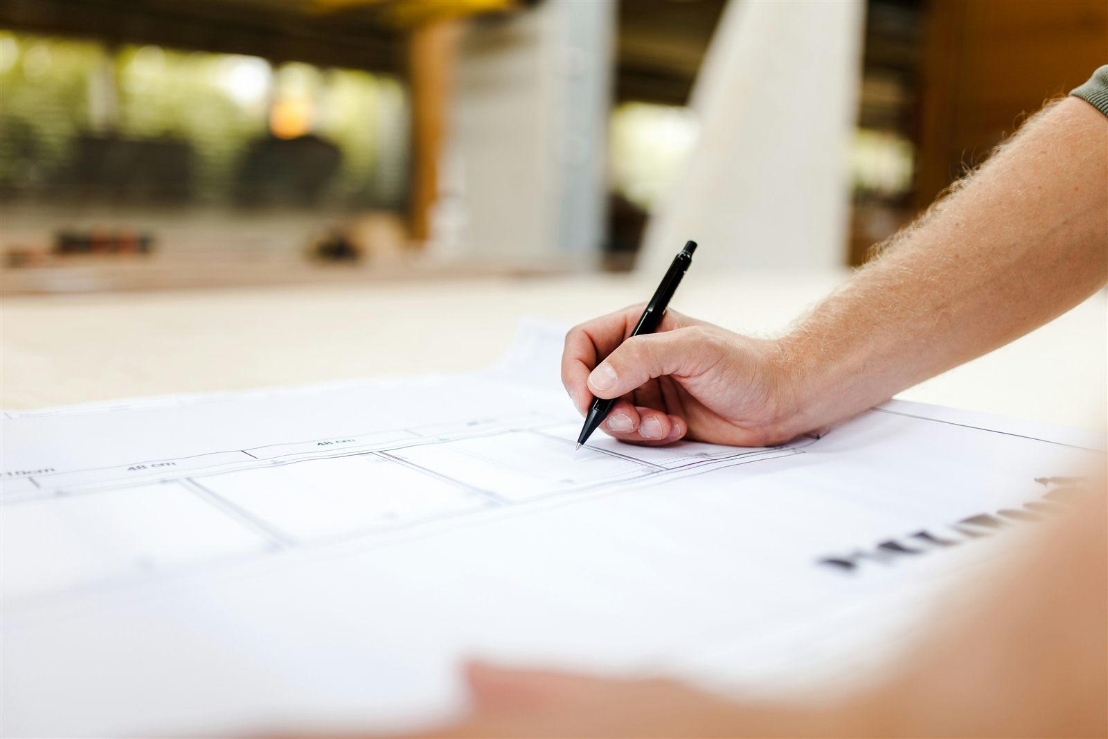 A technical drawing being reviewed by hand